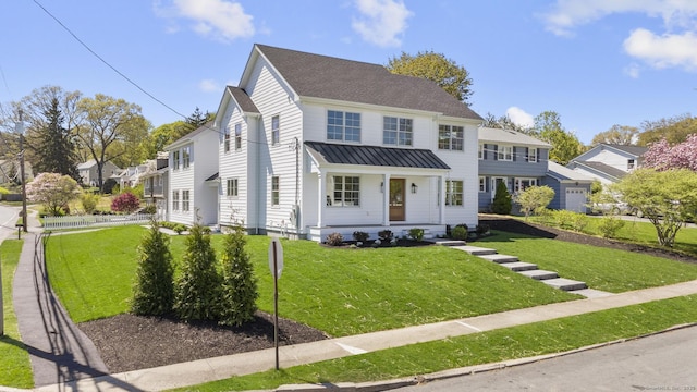 15 Barton Rd, Fairfield, CT 06824 - view of front facade featuring a standing seam roof, a front lawn, and metal roof