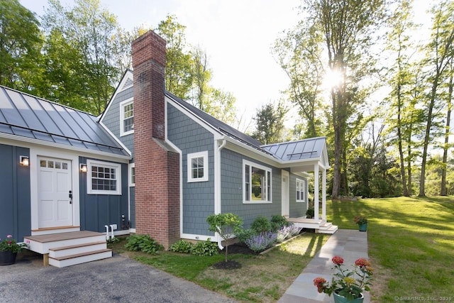 331 Calkinstown Rd, Sharon, CT 06069 - view of front of home featuring a standing seam roof, a chimney, metal roof, and a front lawn