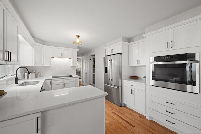 55 Cypress Rd, Old Saybrook, CT 06475 - kitchen featuring stainless steel appliances, light wood finished floors, white cabinets, and light stone counters
