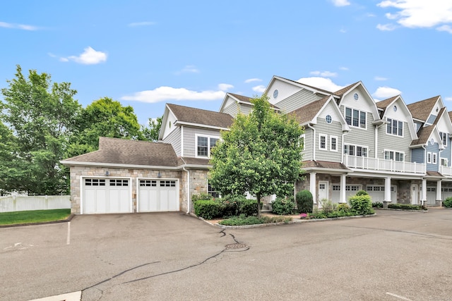 2180 Kings Hwy Unit 1, Fairfield, CT 06824 - view of front of house with stone siding, driveway, an attached garage, and a shingled roof