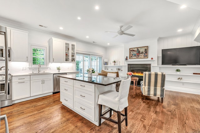 2180 Kings Hwy Unit 1, Fairfield, CT 06824 - kitchen with a sink, appliances with stainless steel finishes, a kitchen bar, crown molding, and ceiling fan