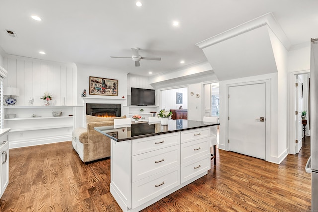 2180 Kings Hwy Unit 1, Fairfield, CT 06824 - kitchen featuring ceiling fan, crown molding, white cabinets, a warm lit fireplace, and wood finished floors