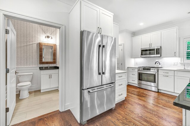 2180 Kings Hwy Unit 1, Fairfield, CT 06824 - kitchen featuring stainless steel appliances, white cabinetry, a sink, and tasteful backsplash