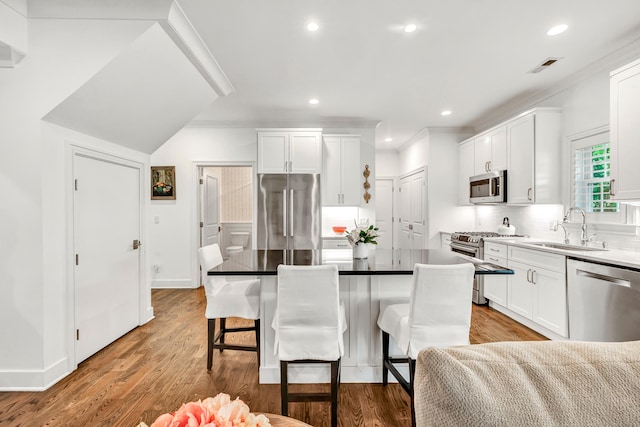 2180 Kings Hwy Unit 1, Fairfield, CT 06824 - kitchen with stainless steel appliances, a sink, a breakfast bar area, tasteful backsplash, and white cabinets