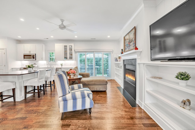 2180 Kings Hwy Unit 1, Fairfield, CT 06824 - living area with a ceiling fan, wood finished floors, ornamental molding, a fireplace with flush hearth, and recessed lighting