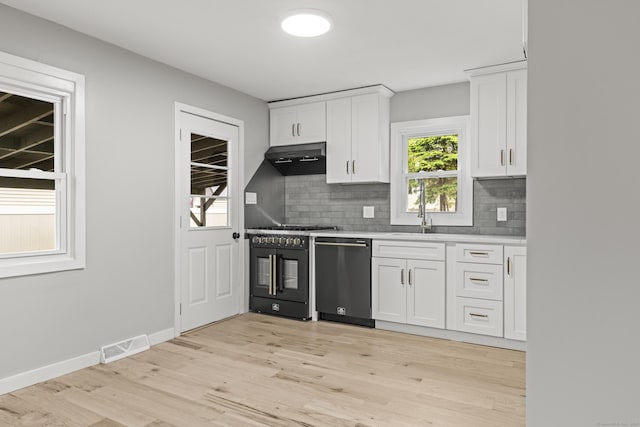 32 Porterbrook Ave, East Hartford, CT 06118 - kitchen with dishwashing machine, black range with gas cooktop, under cabinet range hood, white cabinetry, and backsplash