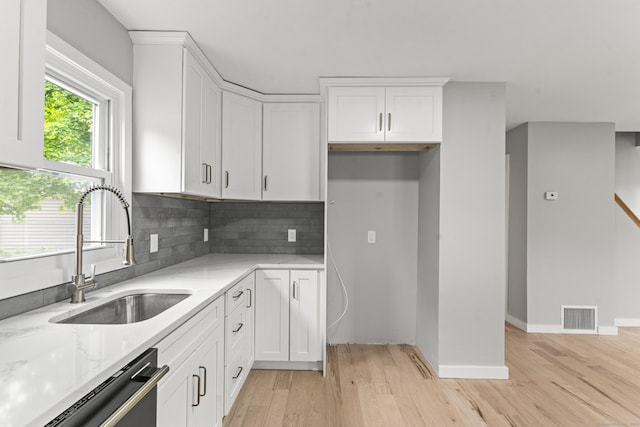 32 Porterbrook Ave, East Hartford, CT 06118 - kitchen with a sink, light stone countertops, light wood-style floors, dishwasher, and white cabinetry