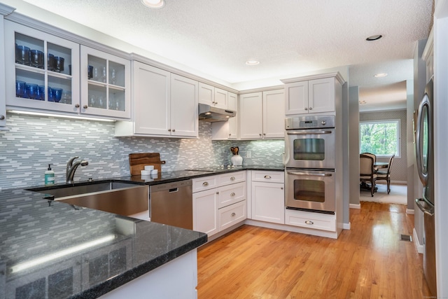 53 Bathcrescent Ln Unit 53, Bloomfield, CT 06002 - kitchen with appliances with stainless steel finishes, a sink, under cabinet range hood, light wood-style floors, and dark stone countertops