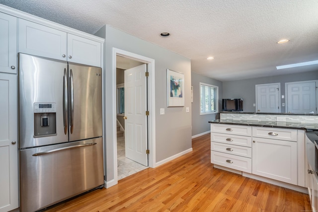 53 Bathcrescent Ln Unit 53, Bloomfield, CT 06002 - kitchen featuring stainless steel fridge with ice dispenser, light wood-style floors, white cabinetry, a textured ceiling, and baseboards