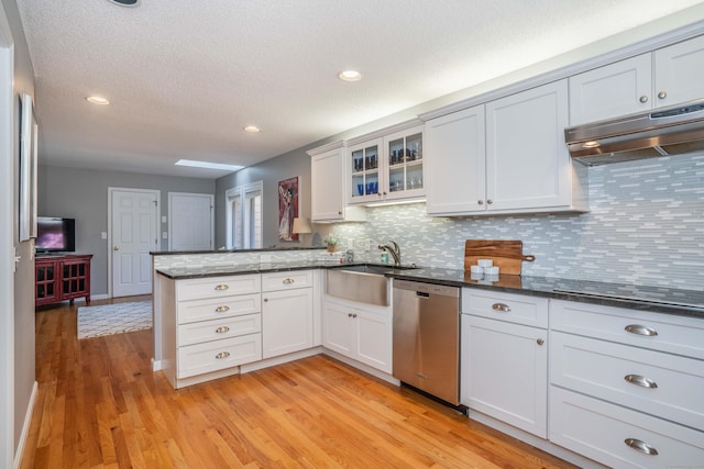 53 Bathcrescent Ln Unit 53, Bloomfield, CT 06002 - kitchen with stainless steel dishwasher, a peninsula, light wood-type flooring, under cabinet range hood, and decorative backsplash