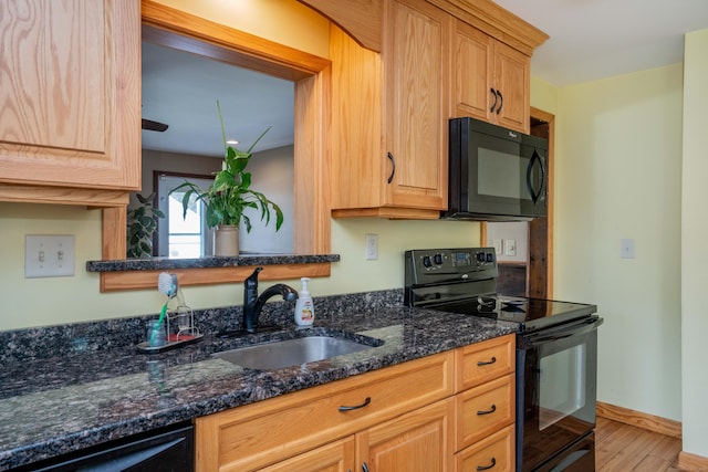115 Ashland Ave, Newington, CT 06111 - kitchen with black appliances, a sink, light wood-type flooring, dark stone counters, and baseboards