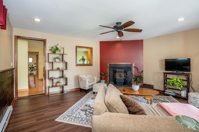 115 Ashland Ave, Newington, CT 06111 - living area with a baseboard heating unit, a wood stove, ceiling fan, baseboards, and wood finished floors