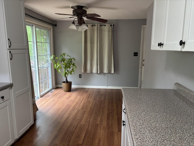 120 Wall St, Meriden, CT 06450 - kitchen featuring a ceiling fan, white cabinets, dark wood-style flooring, light stone countertops, and baseboards