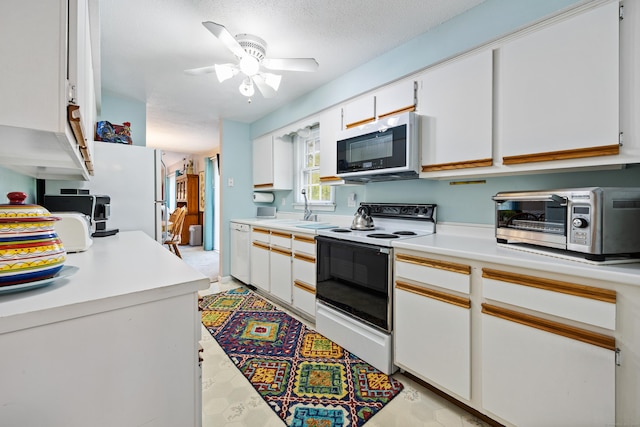 76 River St W, Old Saybrook, CT 06475 - kitchen with white appliances, light countertops, a ceiling fan, and white cabinets