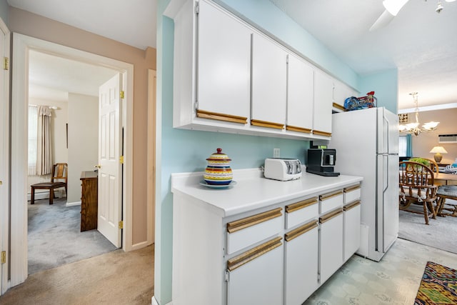 76 River St W, Old Saybrook, CT 06475 - kitchen with light colored carpet, freestanding refrigerator, light countertops, white cabinets, and a baseboard radiator