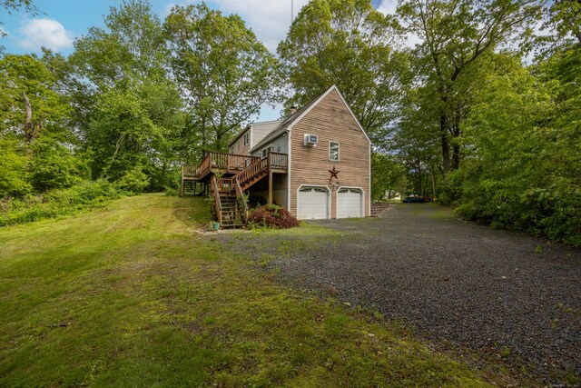 76 River St W, Old Saybrook, CT 06475 - view of side of home featuring stairway, driveway, a garage, a deck, and a lawn