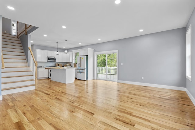 116 Joshua Town Rd, Waterbury, CT 06708 - unfurnished living room featuring light wood-style flooring, recessed lighting, baseboards, and stairway