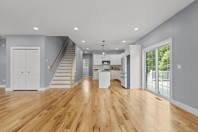 116 Joshua Town Rd, Waterbury, CT 06708 - unfurnished living room featuring light wood-style floors, stairs, recessed lighting, and baseboards