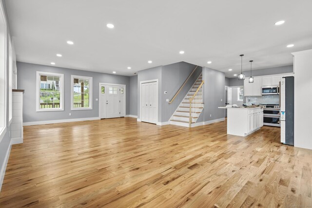 116 Joshua Town Rd, Waterbury, CT 06708 - unfurnished living room with light wood-style floors, recessed lighting, baseboards, and healthy amount of natural light
