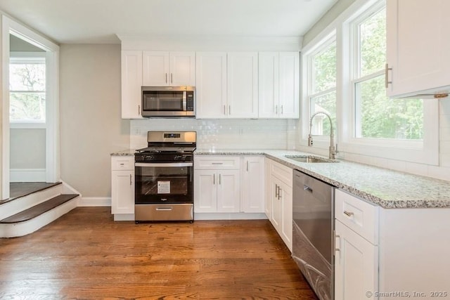 34 Wilbur Ave, Meriden, CT 06450 - kitchen with stainless steel appliances, a sink, decorative backsplash, white cabinets, and light stone counters