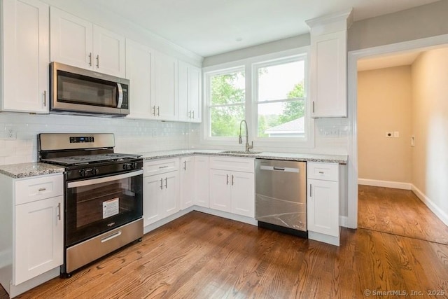 34 Wilbur Ave, Meriden, CT 06450 - kitchen with appliances with stainless steel finishes, a sink, dark wood-style flooring, light stone countertops, and backsplash