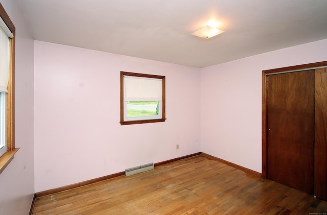 58 Wade St, West Haven, CT 06516 - unfurnished bedroom featuring a baseboard radiator, light wood finished floors, baseboards, and a closet