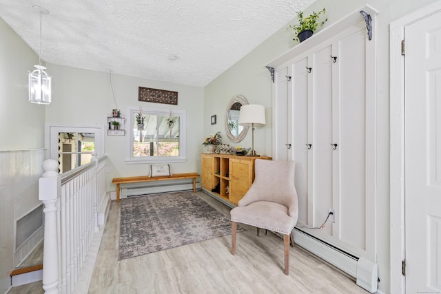 10 Ciccio Ct, Plainville, CT 06062 - sitting room with a baseboard radiator, a textured ceiling, a baseboard heating unit, and light wood-style floors