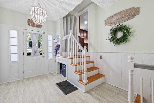 10 Ciccio Ct, Plainville, CT 06062 - foyer entrance featuring wood finished floors, stairs, a chandelier, a textured ceiling, and a wainscoted wall