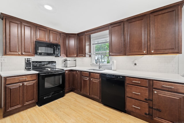 10 Ciccio Ct, Plainville, CT 06062 - kitchen with black appliances, a sink, light wood-style flooring, and light countertops