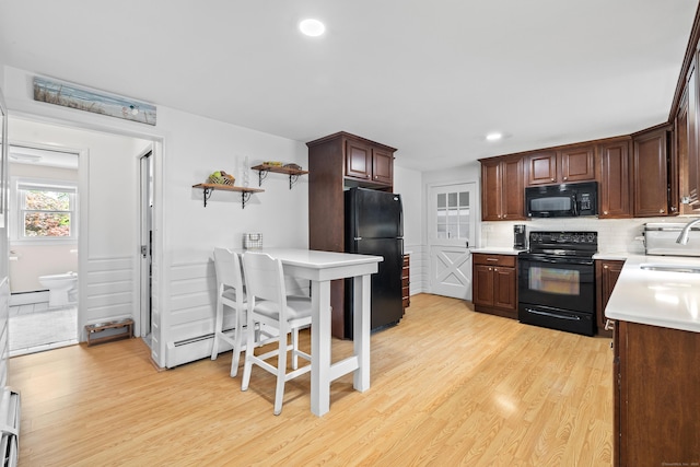 10 Ciccio Ct, Plainville, CT 06062 - kitchen featuring black appliances, light wood-style floors, light countertops, tasteful backsplash, and a sink