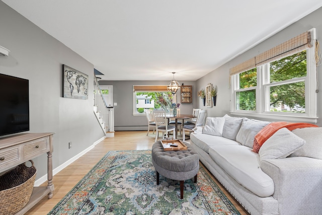 10 Ciccio Ct, Plainville, CT 06062 - living room with stairs, light wood-style flooring, a chandelier, baseboard heating, and baseboards