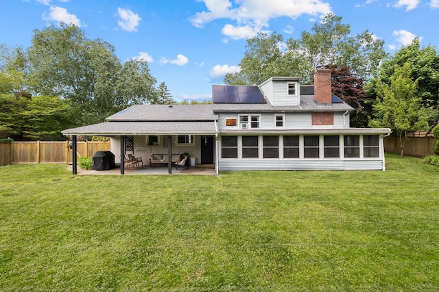 10 Ciccio Ct, Plainville, CT 06062 - back of property with a sunroom, a chimney, a patio, solar panels, and a shingled roof