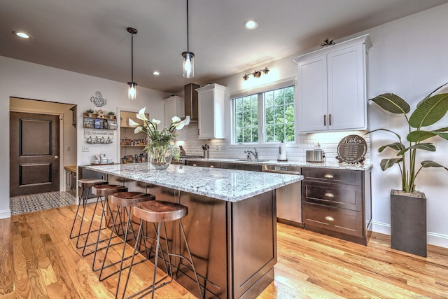 905 New Britain Ave, Farmington, CT 06032 - kitchen with a sink, stainless steel dishwasher, light wood-type flooring, backsplash, and a center island