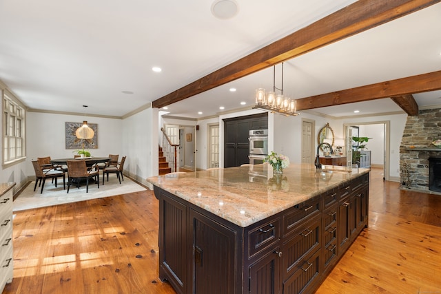 99 Cross Hwy, Redding, CT 06896 - kitchen with a sink, light wood finished floors, beam ceiling, double oven, and light stone counters