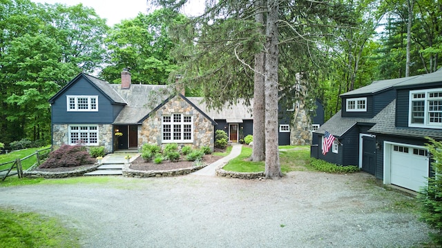 99 Cross Hwy, Redding, CT 06896 - view of front of house with stone siding, dirt driveway, a chimney, an attached garage, and roof with shingles