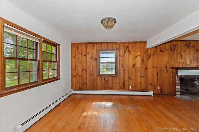 3 Pattagansett Ct, East Lyme, CT 06357 - unfurnished living room with baseboard heating, hardwood / wood-style floors, wooden walls, a baseboard radiator, and a fireplace
