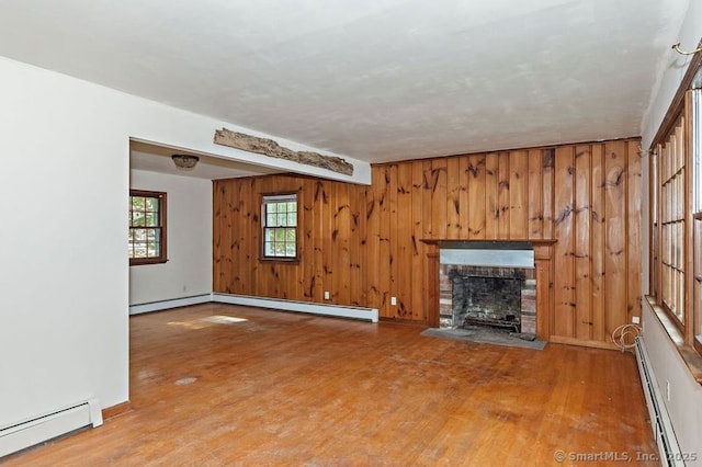 3 Pattagansett Ct, East Lyme, CT 06357 - unfurnished living room featuring a baseboard radiator, baseboard heating, a brick fireplace, wood finished floors, and wood walls