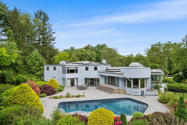 37 Topfield Rd, Wilton, CT 06897 - back of property with a patio, roof mounted solar panels, and an outdoor pool