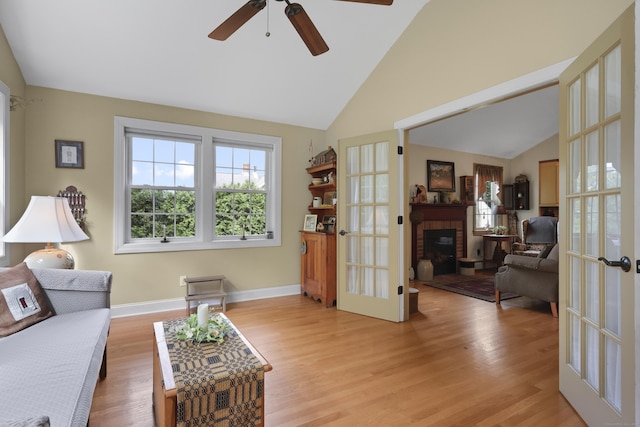 50 Clinton St, Glastonbury, CT 06033 - living area with lofted ceiling, french doors, ceiling fan, a fireplace, and light wood-style flooring