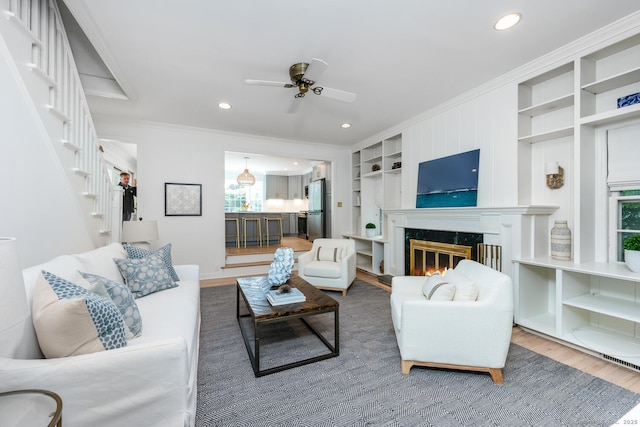 19 Bryan Rd, Norwalk, CT 06853 - living room with crown molding, wood finished floors, a ceiling fan, a fireplace, and stairs