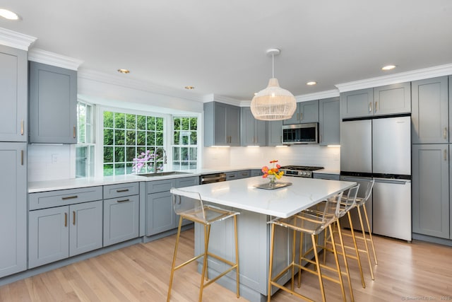 19 Bryan Rd, Norwalk, CT 06853 - kitchen featuring stainless steel appliances, a sink, a kitchen bar, gray cabinetry, and decorative backsplash