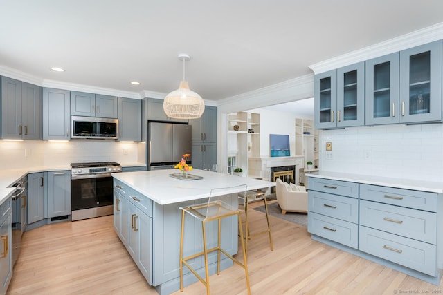 19 Bryan Rd, Norwalk, CT 06853 - kitchen with stainless steel appliances, a breakfast bar, light wood-style flooring, decorative backsplash, and ornamental molding