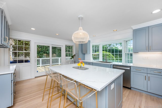 19 Bryan Rd, Norwalk, CT 06853 - kitchen with stainless steel dishwasher, light wood-type flooring, a center island, light stone countertops, and a breakfast bar area