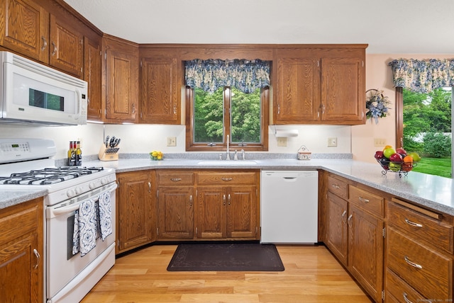 132 Royal Oak Dr, Southington, CT 06489 - kitchen with white appliances, a sink, light wood-style flooring, and light countertops