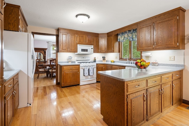 132 Royal Oak Dr, Southington, CT 06489 - kitchen with white appliances, healthy amount of natural light, a peninsula, and brown cabinetry