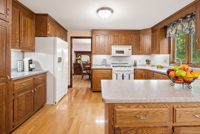 132 Royal Oak Dr, Southington, CT 06489 - kitchen featuring white appliances, light wood-style flooring, light countertops, brown cabinets, and a peninsula