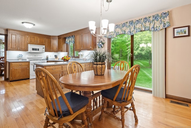 132 Royal Oak Dr, Southington, CT 06489 - dining area featuring light wood-style floors, a chandelier, and healthy amount of natural light