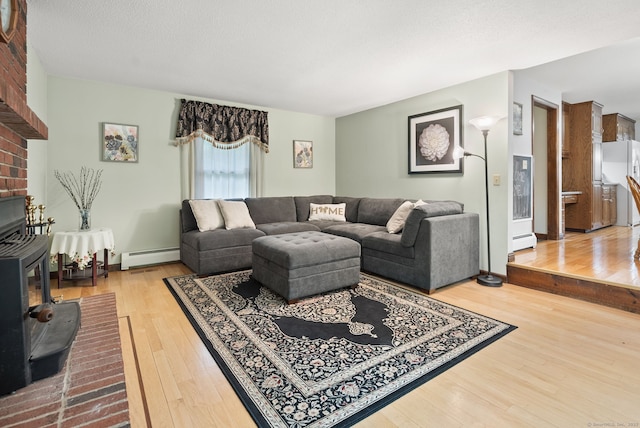 132 Royal Oak Dr, Southington, CT 06489 - living room with a wood stove, a baseboard radiator, and wood finished floors