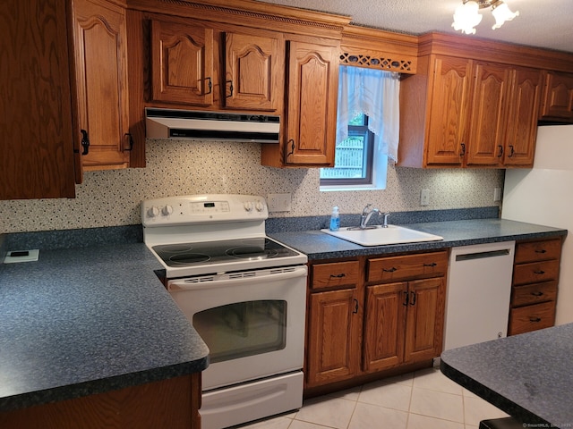 13 Little River Ln, Middletown, CT 06457 - kitchen featuring white appliances, under cabinet range hood, a sink, dark countertops, and brown cabinets