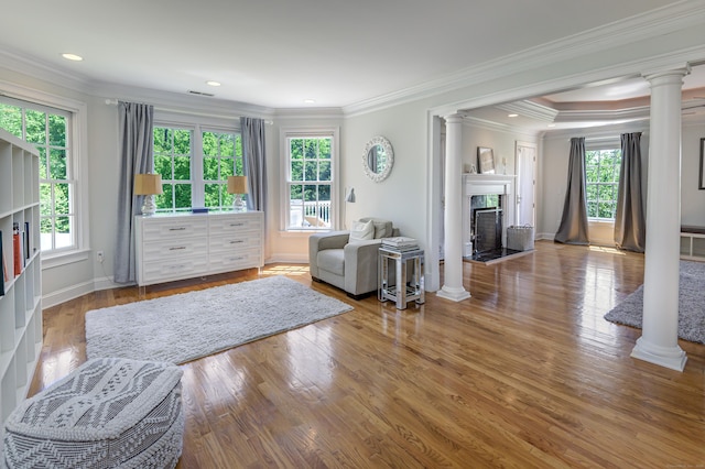 134 Nod Rd, Ridgefield, CT 06877 - living area with ornate columns, a fireplace, healthy amount of natural light, wood finished floors, and ornamental molding